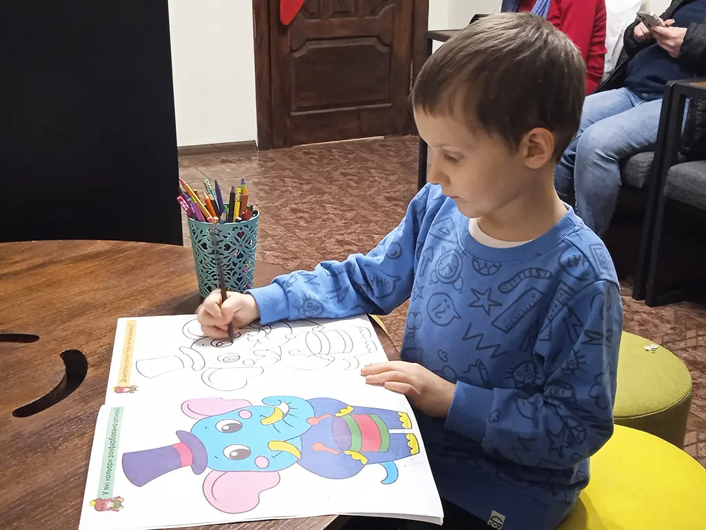 Timosha colors the picture with pencils